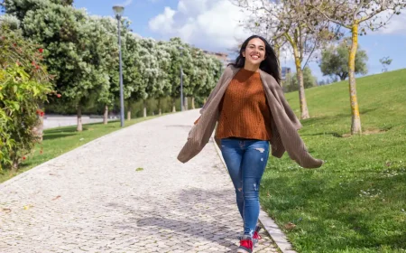 Frau geht fröhlich spazieren – Bewegung hilft, die Lust aufs Rauchen zu vergessen und typische Nebenwirkungen beim Rauchstopp zu lindern.